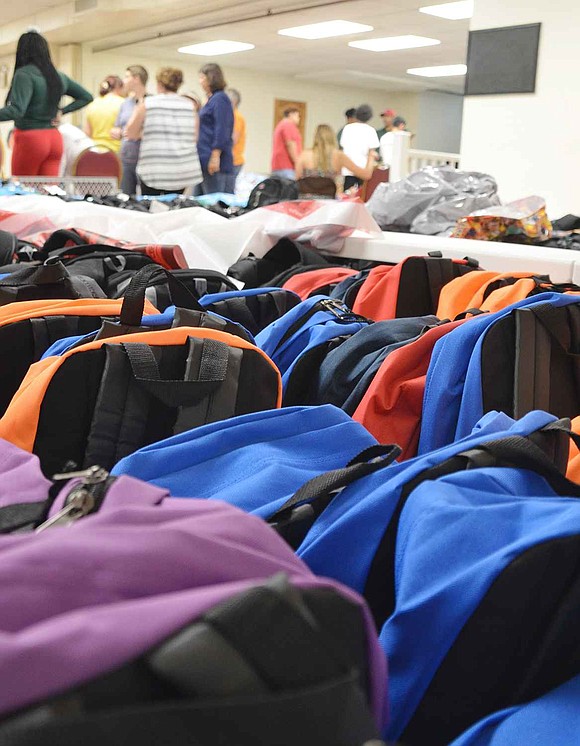  Rows of backpacks stuffed with school supplies sit ready to be picked up by social workers and community groups. 