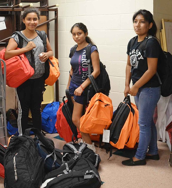  After volunteering at Helping Hands for the Homeless & Hungry annual event on Tuesday, Aug. 18 at Church of the Resurrection in Rye, three Port Chester girls pick up the bags destined for the learning center at St. Peter's Episcopal Church. From left: Iris Escobar, Esmerelda Salcedo and Judy Cacsire. 