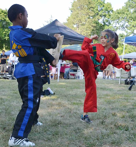  Port Chester's Asha Kammermann, 6, kicks a board in half during a demonstration by students from Grandmaster Byung Min Kim's Tae Kwon Do on North Main Street.