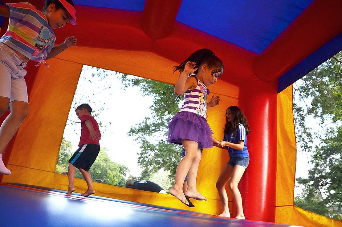  Three-year-old Kayla Castro of Haines Boulevard jumps in the inflatable bounce house. 