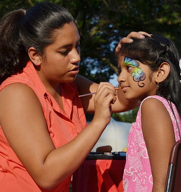  Seven-year-old Greeshma Gavarasana of Westchester Avenue sits still as Claudia Benitez of White Plains puts the finishing touches on her face paint.