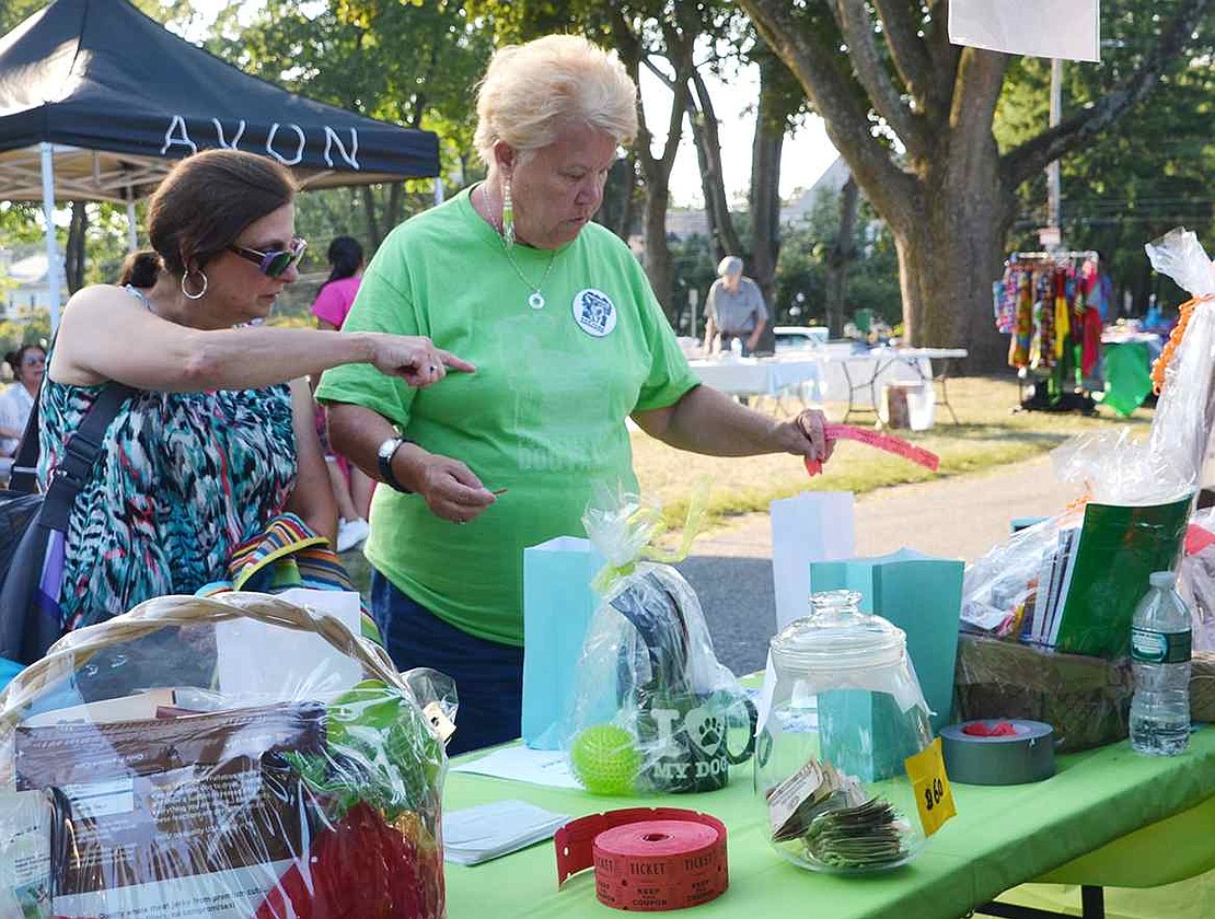  Joyce Rytelewski (right) helps her neighbor, Bernadette Vinci of Birch Street, decide which prizes to try for in the Dog Park Group's Chinese auction . The Port Chester Dog Park is expected to open at Abendroth Park mid-September. 