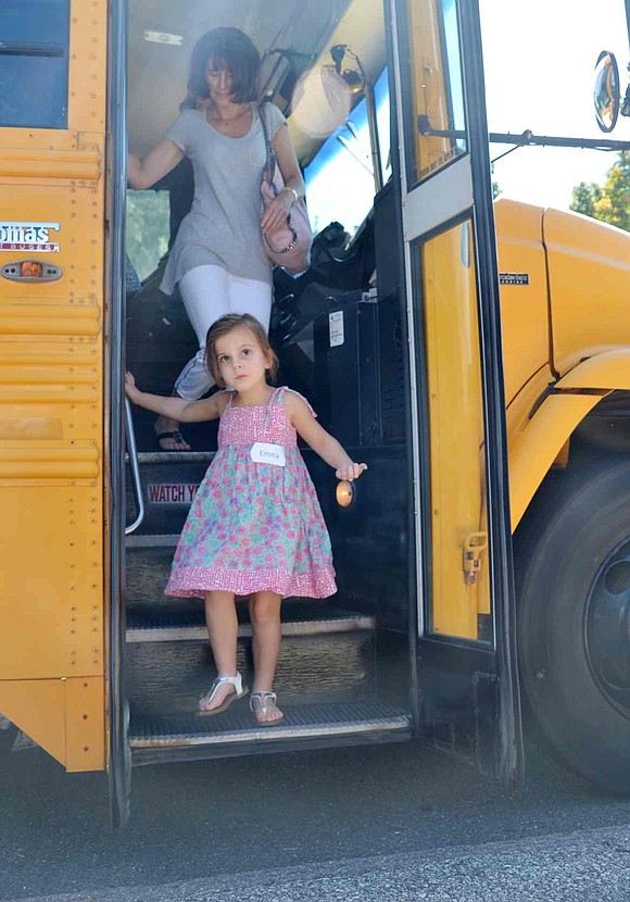  Emma Ashley climbs down after her first time riding on the big yellow school bus. 