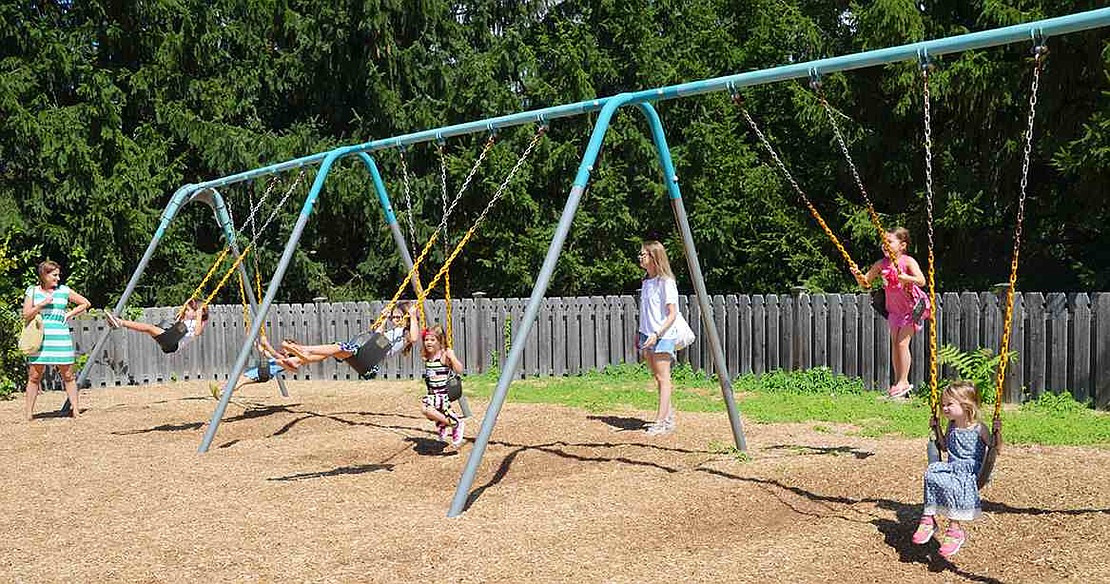  Students in Brenda Johnson's and Shannon LaRoche's kindergarten classes play on the swings. 