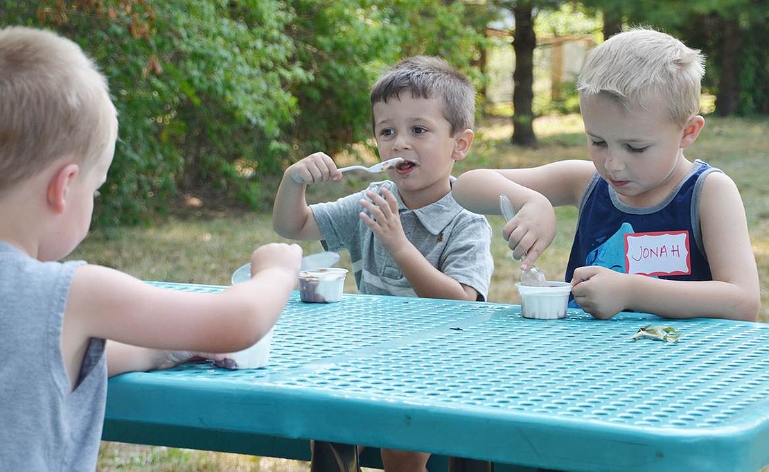  Future King Street School students Evan Helmle (left) and Luke Doherty enjoy cups of ice cream with kindergartner Jonah Helmle. 