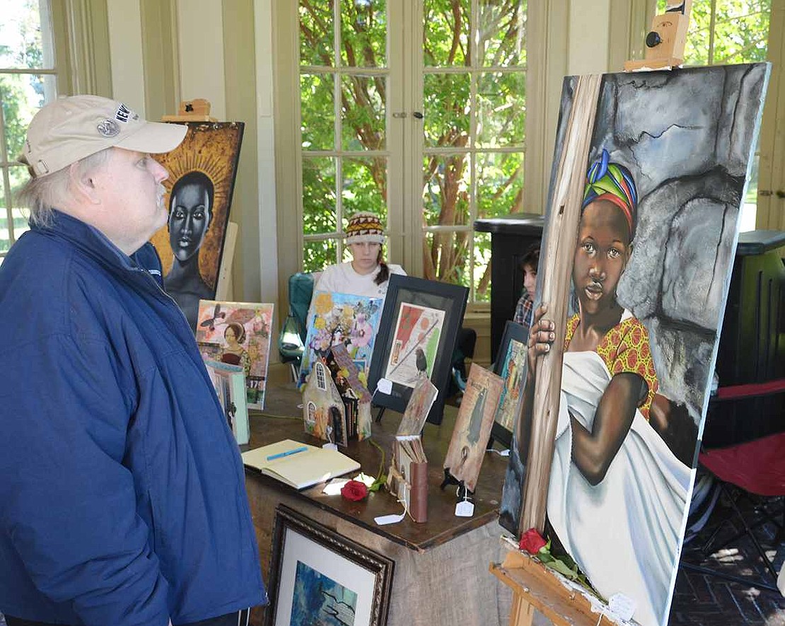  Brian Sullivan's attention is caught by the painting of a Congo woman made by fellow Port Chester resident Ileana Hernandez Carafas.