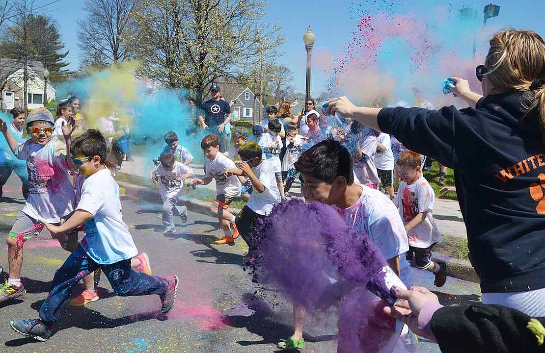 <p class="Picture">Volunteers toss colored dust at the running children. The Park Avenue School PTO organized the Color-A-Thon&mdash;a small, kid-friendly version of a Color Run&mdash;as a new fundraiser on Sunday afternoon, Apr. 17. More than 100 people participated, raising a little over $5,000 for the Parent Teacher Organization.</p>