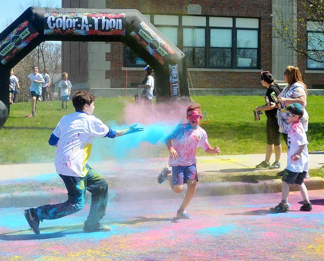 <p class="Picture">One boy throws a handful of bright blue powder at another boy participating in the Color-A-Thon.&nbsp;</p>