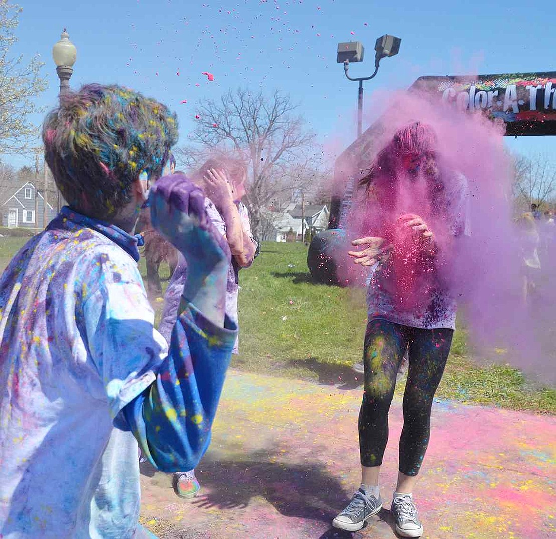 <p class="Picture">One boy throws a handful of bright pink powder dead-on at a woman participating in the Color-A-Thon.&nbsp;</p>