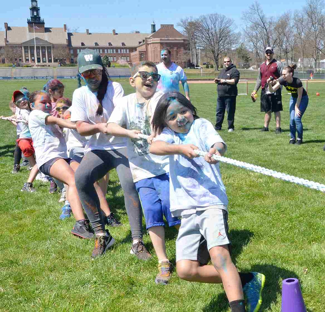 <p class="Picture">Still covered in a variety of colors, students use up some more energy during a tug-o-war after the run is over. Besides some yard games, there was also a dance session as part of the Color-A-Thon.&nbsp;</p>