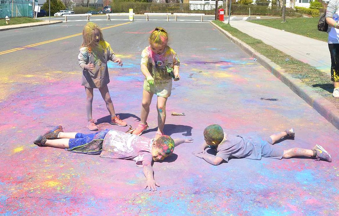 <p class="Picture">Deciding they do not have enough dust on him, Park Avenue School first-graders Dominick Luzzi and Roy Morris roll around on the ground in a pile of the colorful detritus left behind after the run is completed even as two girls sprinkle more onto them.&nbsp;</p>