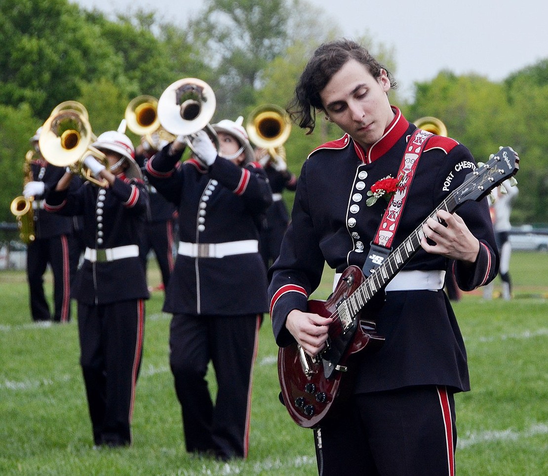 <p class="Picture">For that added rock element, Colby Quinlan, a senior, plays the electric guitar during the Port Chester High School Marching Band&rsquo;s Queen-themed field show.&nbsp;</p>