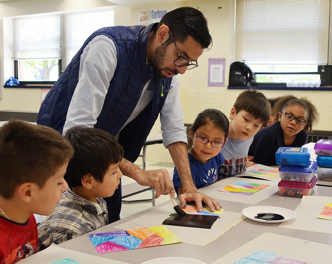 <p class="Picture">Mario Rodriguez shows Edison School kindergartners how to paint over their crayon drawings with black paint on Friday, May 20 as part of National Arts in the School Day. Later the students will be able to scratch away the black paint revealing the colors underneath.&nbsp;</p>