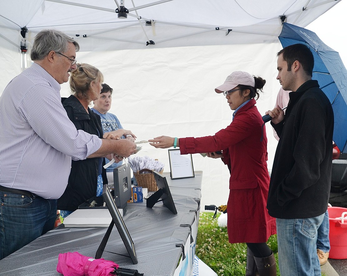 <p class="Picture">Port Chester Village Trustee Bart Didden sells day-of tickets to Chrystal Szeto and Ryan Zager. The duo from Milford, Conn. came out despite the weather to meet up with a friend who lives in Port Chester.&nbsp;</p>