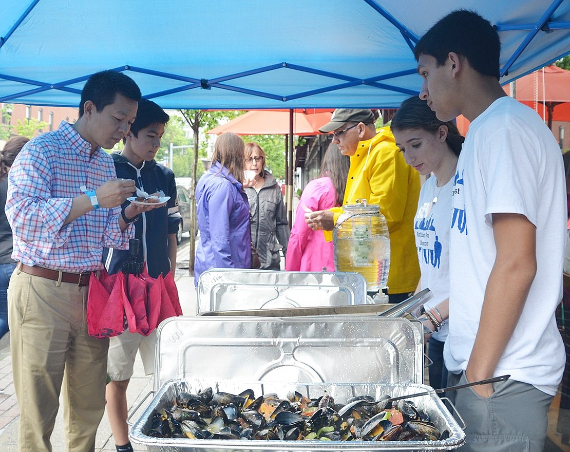 <p class="Picture">In front of Acuario on North Main Street, lomo saltado, fries and chicken and savory mussels get dished up by Anthony Foust mentors Alfred DiLeo and Taylor Masi from Port Chester High School.</p>