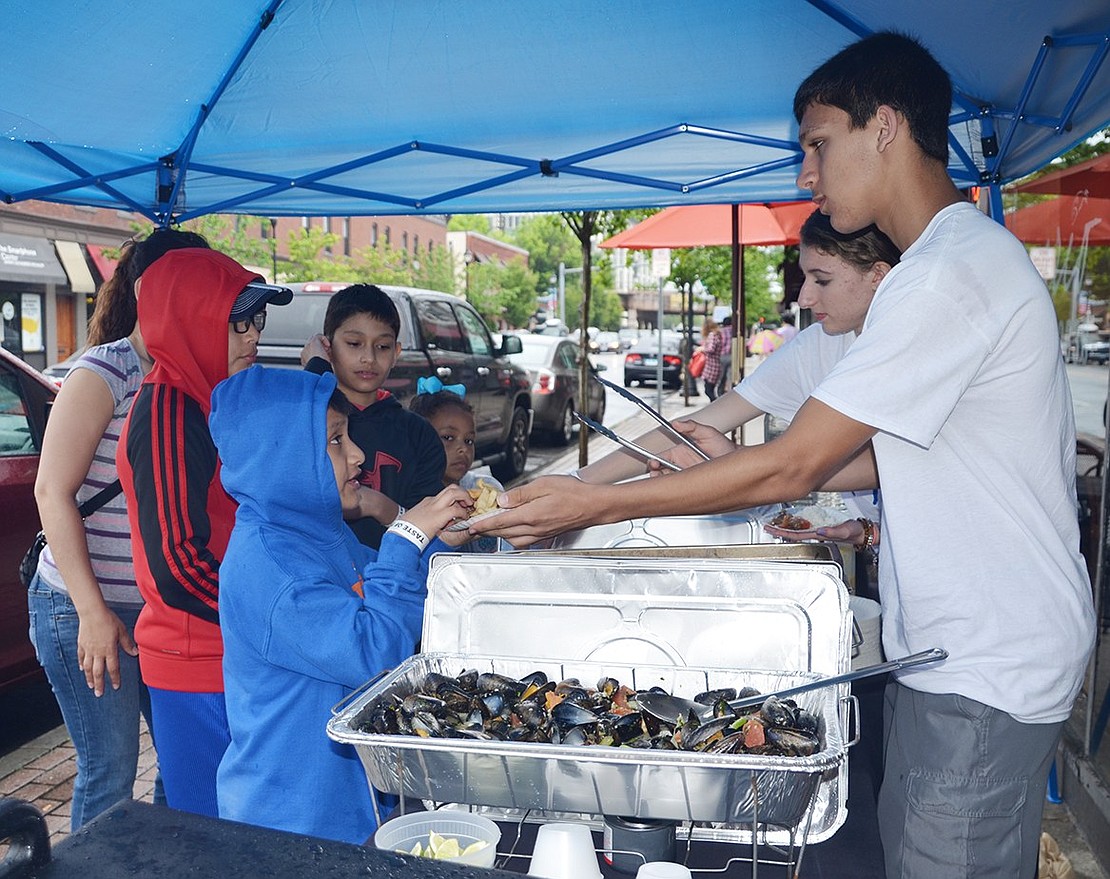 <p class="Picture">In front of Acuario on North Main Street, lomo saltado, fries and chicken and savory mussels get dished up by Anthony Foust mentors Alfred DiLeo and Taylor Masi from Port Chester High School.</p>