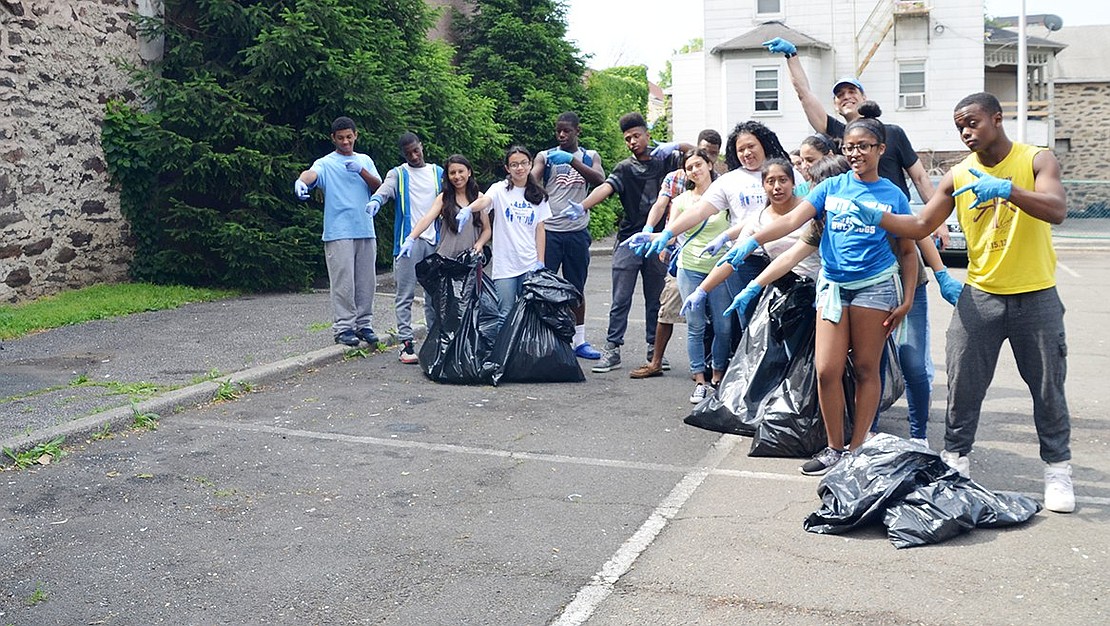 A group of Port Chester High School students, along with Beautification Commission&nbsp;member Lou Del Bianco, point to the now empty corner of the parking lot at 45&nbsp;Traverse Ave. The spot had been covered in trash until the students cleared it up.