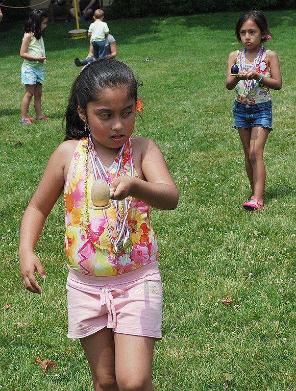 Seven-year-old Jazlyn Fernandez of Port Chester concentrates intently as she carries a wooden egg on a spoon so as not to drop it.