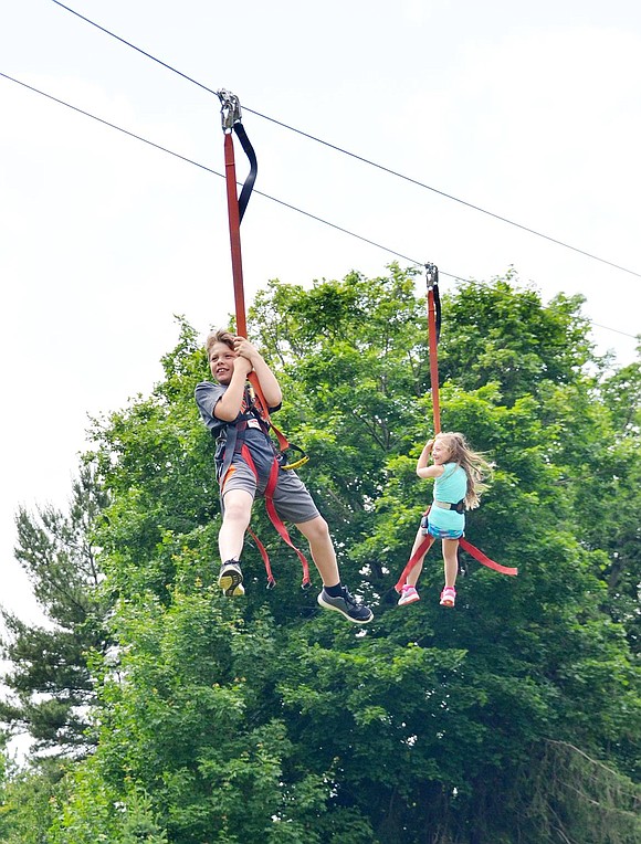 <p class="Picture">Former Rye Brook residents Alexander Baribault, 8, and his younger sister, Isabella, 5, fly through the air on the zip line set up in Crawford Park.&nbsp;</p>