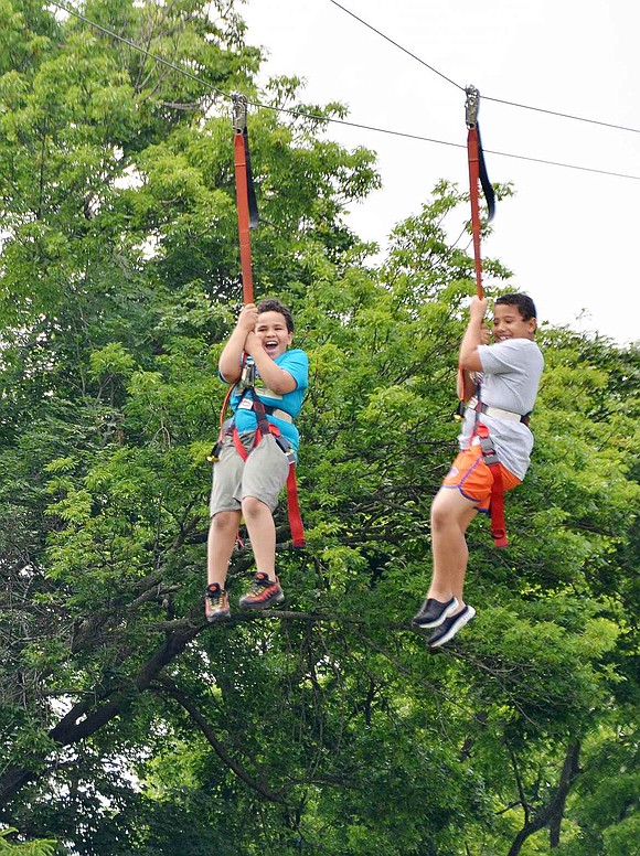 <p class="Picture">Port Chester 8-year-olds Aidyn Richmond (left) and Tristan Jackson fly through the air on the zip line set up in Crawford Park.&nbsp;</p>