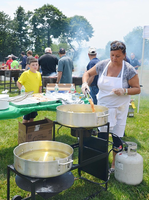 <p class="Picture">Sandie Vecchio carefully handles the pizza dough for the pizza frites. The periodic rain showers combined with the hot oil made the frying a challenge on Saturday afternoon.&nbsp;</p>