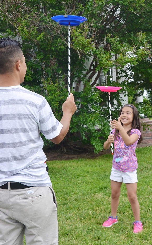 <p class="Picture">Seven-year-old Alyssa Lopez of Port Chester follows her father&rsquo;s lead, balancing a spinning plate on top of a stick.&nbsp;</p>