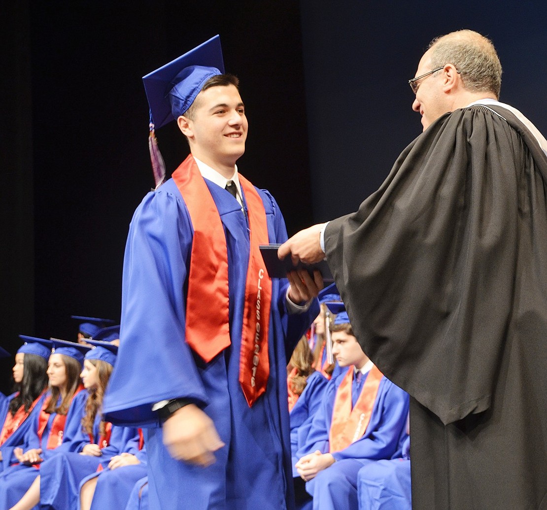 Jacob Singer receives his diploma from Board of Education President Jeff Diamond.