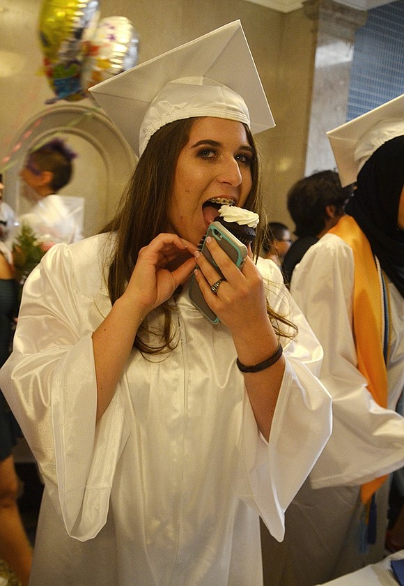 <span style="font-family: Arial; font-size: 10px;">Brittany Bunjaporte bites into a cupcake provided for graduates by the PTSA after the graduation ceremony.&nbsp;Richard Abel|Westmore News<br /> </span>