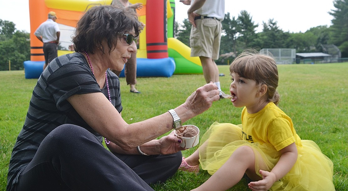 <p class="Picture">Eloise Tunis, 3, is more than happy to get ice cream on her yellow tutu as she is fed by Nancy, her relative on Pine Ridge Road.</p>