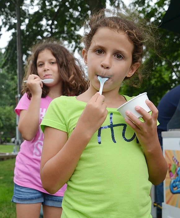 <span style="font-family: Arial;">Cassandra Brunetti, 7, and her sister Grace, 9, dive into their blueberry and vanilla ice cream, not caring if it colors their faces blue and white.&nbsp;</span>