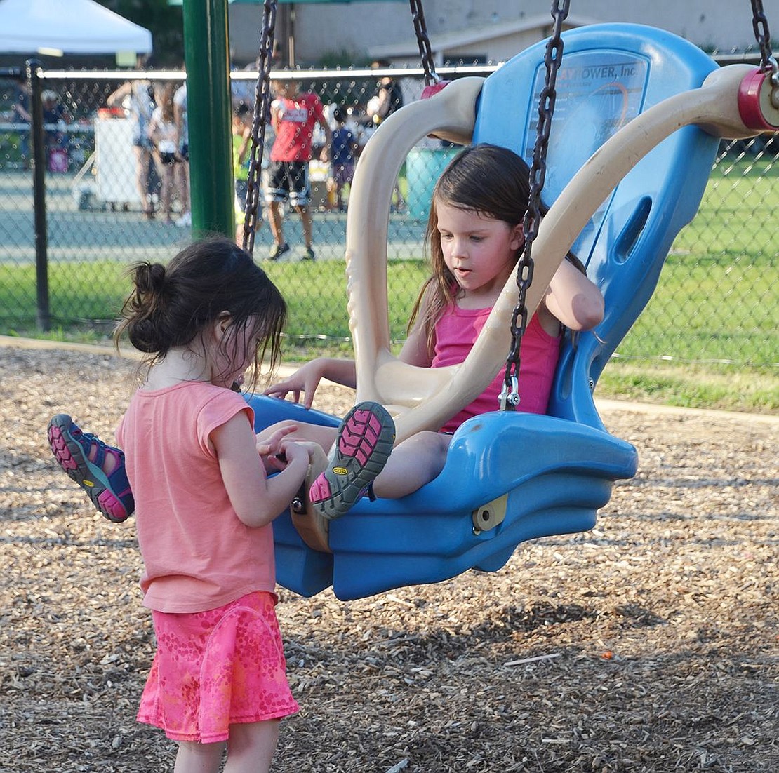 <p class="MsoNormal">Rye Brook resident Caroline Shaver, 3, helps strap in her big sister Campbell Shaver, 6, into a swing.&nbsp;</p>