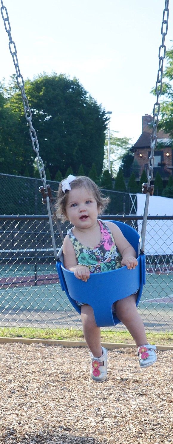 <p>Rye Brook resident Victoria Shaver, 1, smiles in delight as she swings her higher than she has ever gone before.&nbsp;</p>