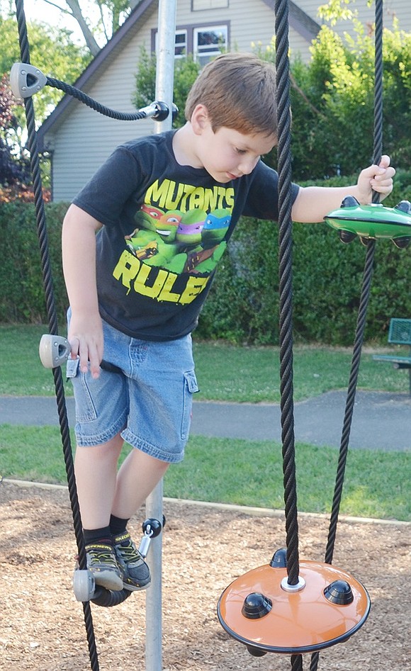 <p class="MsoNormal">Joshua Simkin, 7, of Rye Brook, tests his grip and balance on the park&rsquo;s new rope course, calling for his father to videotape his skills.</p>
