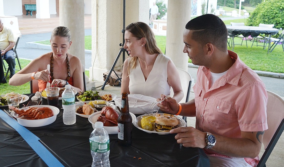 <p class="Picture">Angela and Chrissy Manning and David Rivera of Port Chester dig into their feast of lobster, pasta salad, burgers and corn.&nbsp;</p>