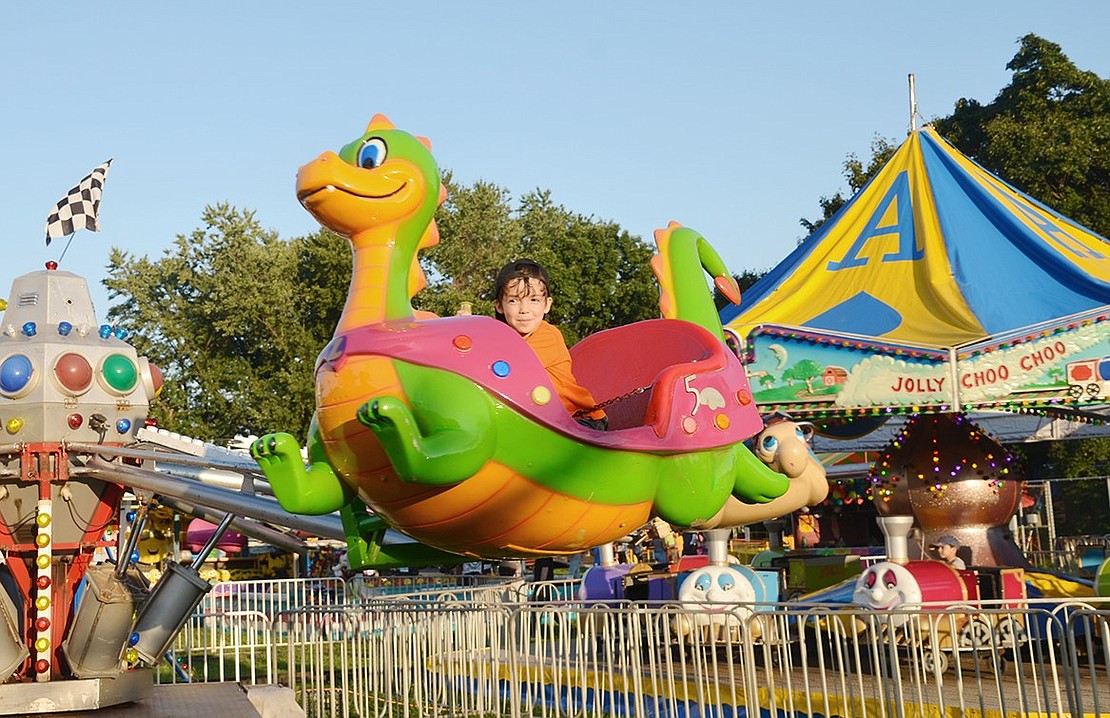 Five-year-old Logan Massa of Port Chester takes to the sky on a green dragon during the Corpus Christi-Holy Rosary Church Carnival, which ran throughout the week of Aug. 14 on the field behind Corpus Christi Church on South Regent Street.&nbsp; <div> <div> <div id="_com_1" class="msocomtxt" language="JavaScript"> <!--[if !supportAnnotations]--></div> <!--[endif]--></div> </div>