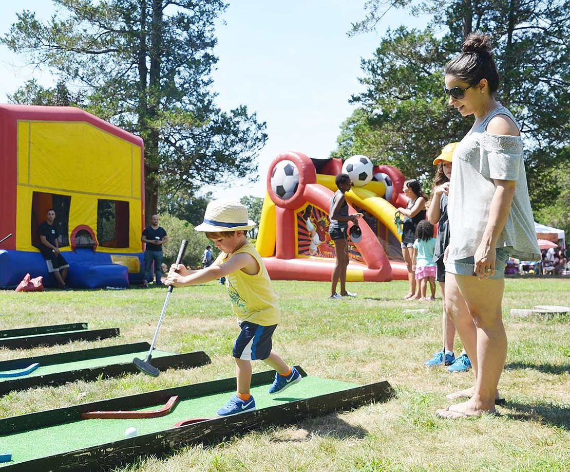 <p class="Picture">Two-year-old Port Chester resident M.J. O&rsquo;Neill pushes the putt-putt golf ball around like he is playing shuffleboard while his mother Steffany and his 5-year-old sister Holly watch.</p>