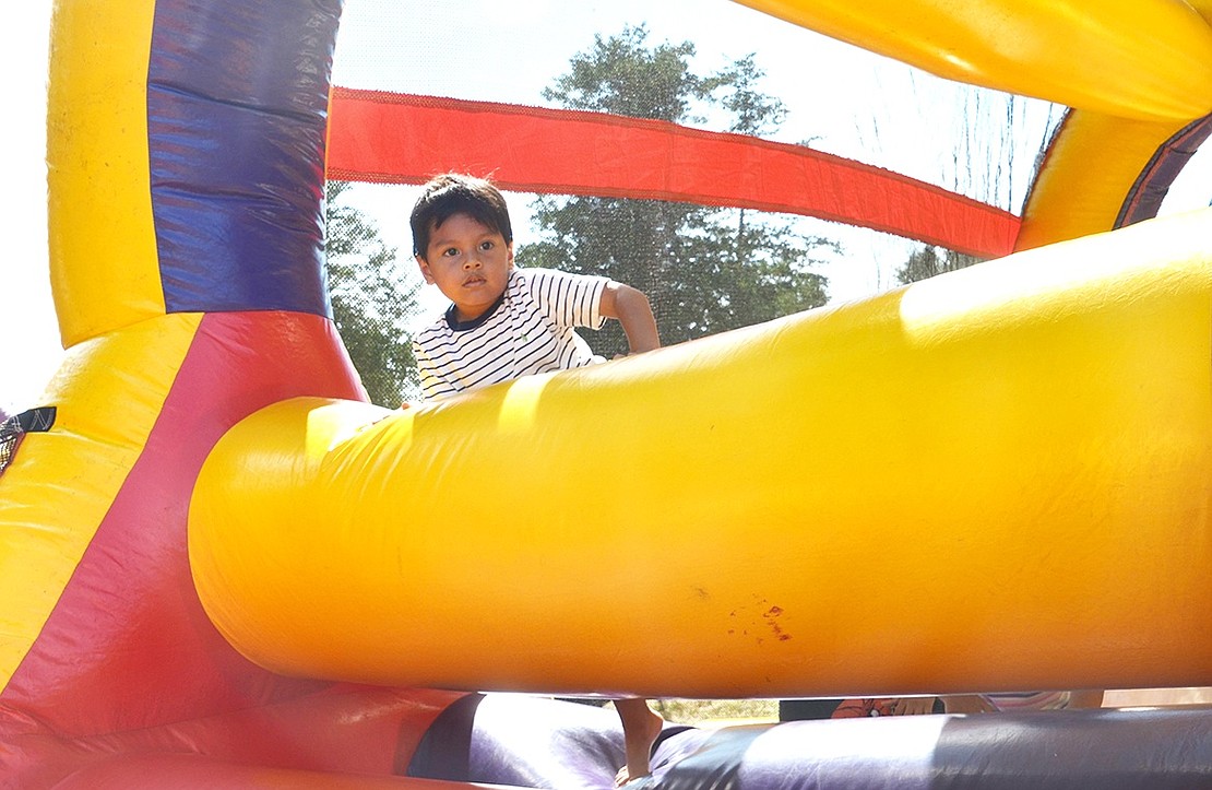 <p class="Picture">Port Chester resident Braydan Cando, 4, peers over the obstacle course and looks to his father, who rooted for him the entire way.&nbsp;</p>