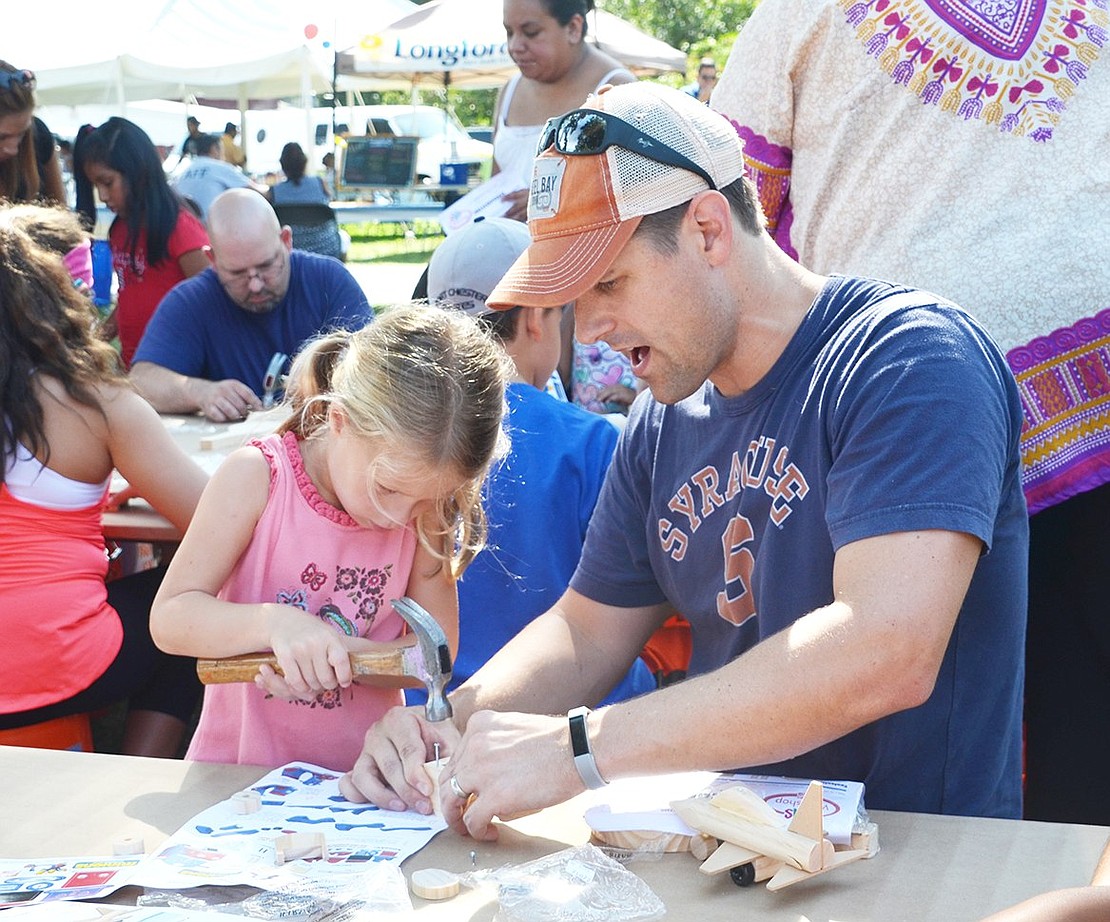 <p class="Picture">Marina Kean, 4, and her father Dan of Rye Brook put together a small wooden firetruck at the Home Depot table.&nbsp;</p>