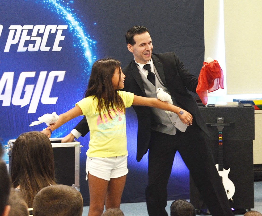 <p class="Picture">Sophia Gonzalez, 9, not only helped sell t-shirts at the Kindergarten Social, but helps magician and sixth grade Blind Brook Middle School teacher Tom Pesce by being a roost for his pet doves.&nbsp;</p>