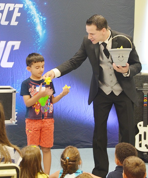 <p class="Picture">The new students witness the magic of Tom Pesce. Five-year-old Rye Brook resident Ishan Dagar helps fill an empty bucket with magically appearing stars created from all the excitement and good thoughts of friendship in the room during the Kindergarten Social at Ridge Street School on Tuesday, Aug. 30. Photo story by Casey Watts, Westmore News.&nbsp;</p>