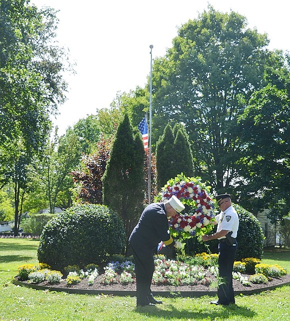 <p class="Picture">Port Chester Fire Chief Edward Quinn and Police Chief Richard Conway place a commemorative wreath in front of Lyon Park&rsquo;s Twin Tower monument. The garden in front of the monument features red, white and blue flowers arranged to look like the American flag.</p> <p class="Right">Casey Watts|Westmore News</p>