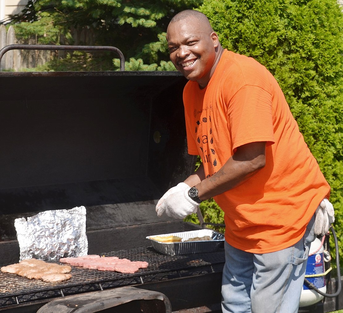 <p class="Picture">William Ross of Oak Street puts some more burgers on the grill.</p>