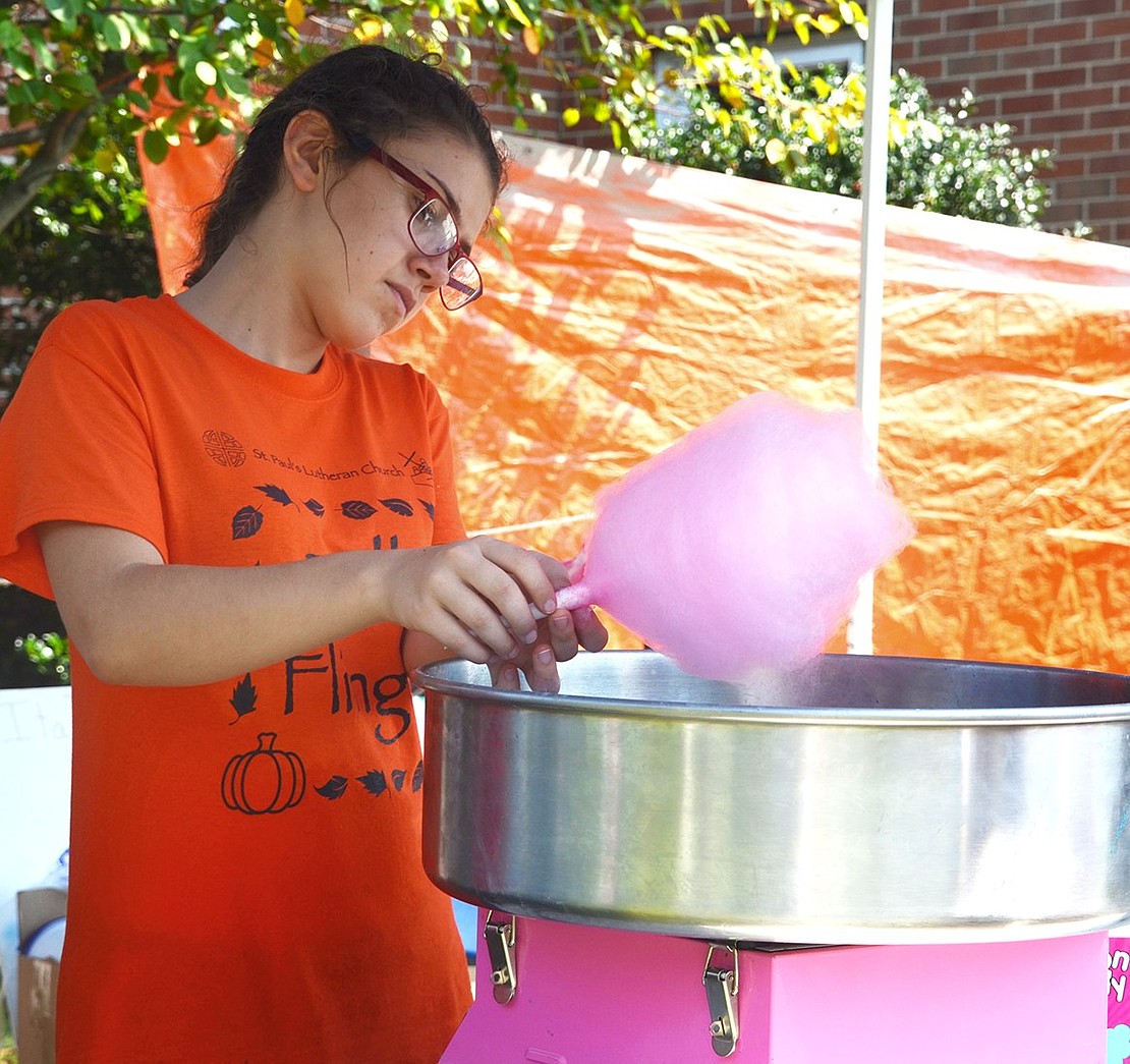 <span style="font-family: Arial;">Kara Hodge, 13, of Park Avenue makes cotton candy at the fall fair.</span>