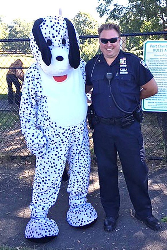 <p class="Picture">Port Chester Police Officer Thomas Krempa, who handles animal control for the village, poses with Spot in front of the rules and regulations sign at the entrance to the dog park located within Abendroth Park.</p> <p class="Right">Courtesy of Linda Turturino</p>