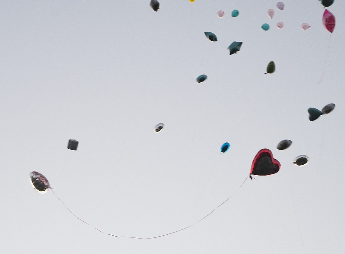 <p class="Picture">Two heart balloons intertwine as they float to the heavens, carrying messages of love from grieving parents. They were the last to ascend and the last to disappear into the setting sun.&nbsp;</p>