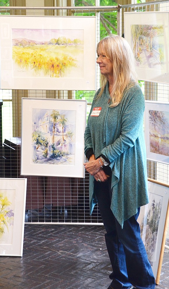 <p class="Picture">Carole Nelson of Greenwich, Conn., poses for a picture as a memento for two ladies who purchased a piece of her art.&nbsp;</p>