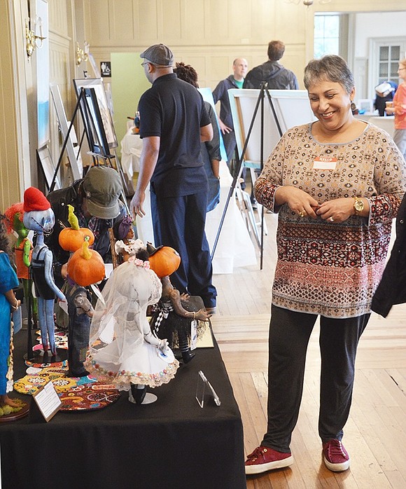 <p class="Picture">Port Chester artist Ileana Hernandez Carafas explains her polymer clay and cloth dolls to passersby. She looks upon her work with nothing but smiles.&nbsp;</p>
