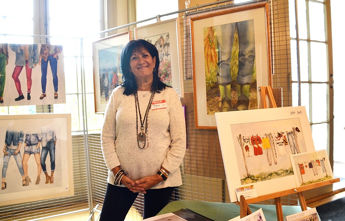 <p class="Picture">Rye Brook artist Joyce Askinasi poses with her work. The Country Ridge Drive artist hopes her portraits bring out emotions and memories to those who view them.&nbsp;</p>