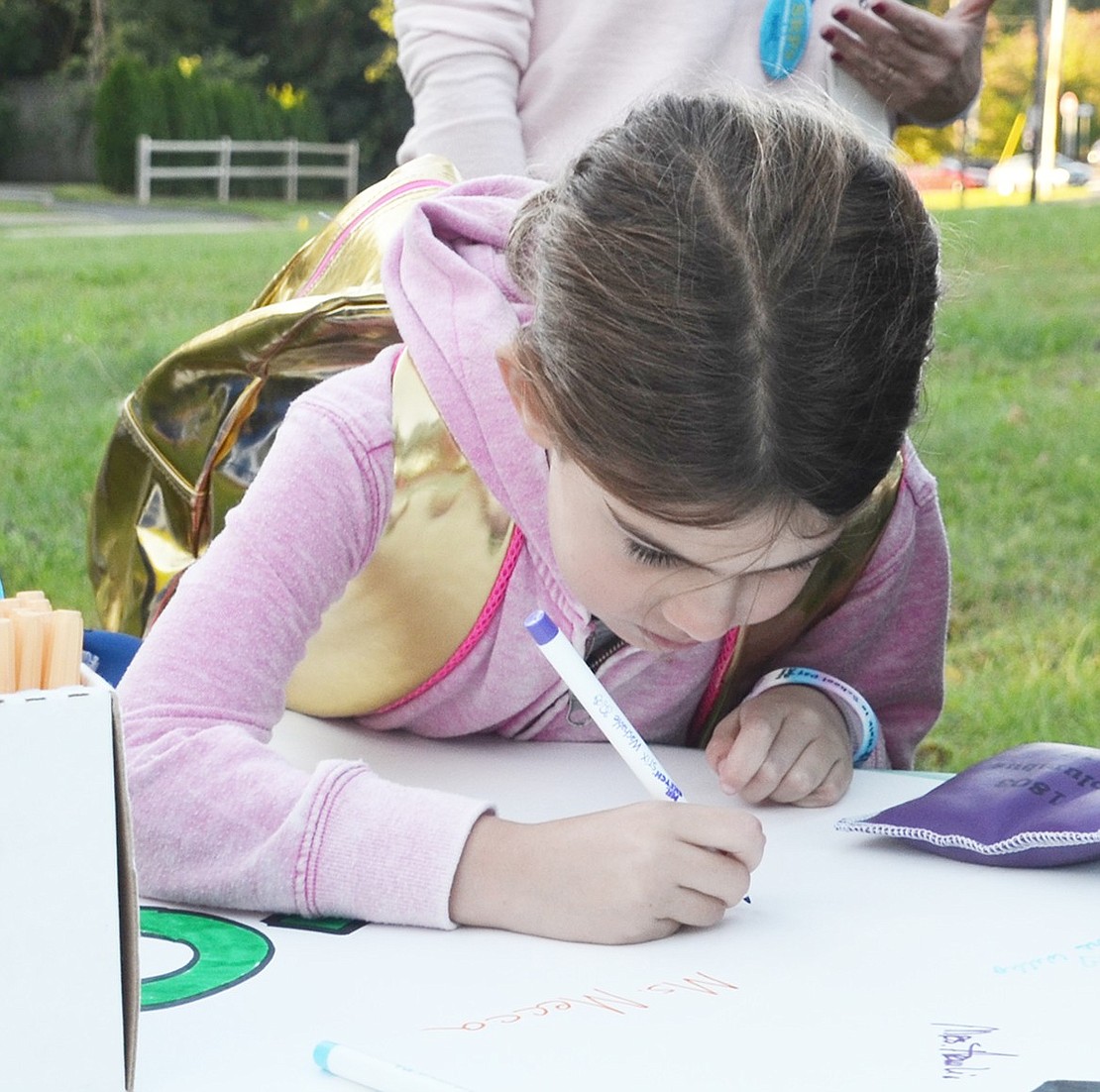 <p class="Picture">First grader Emma Balik-Klein was the first to arrive and the first student to sign her name on Walk to School Day.&nbsp;</p>