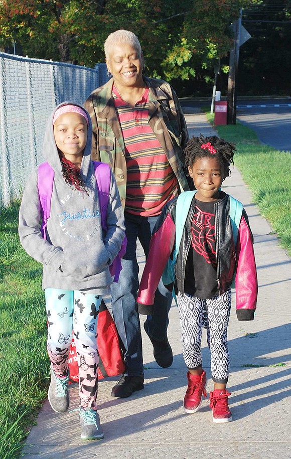 <p class="Picture">Fourth grader Kaliyah Epps and second grader Swayda Hunter, walking with teacher&rsquo;s aide Cheryl Reid, were the first to arrive at school Wednesday morning. They trekked a good distance from Bush, Irving and Haseco avenues.</p>